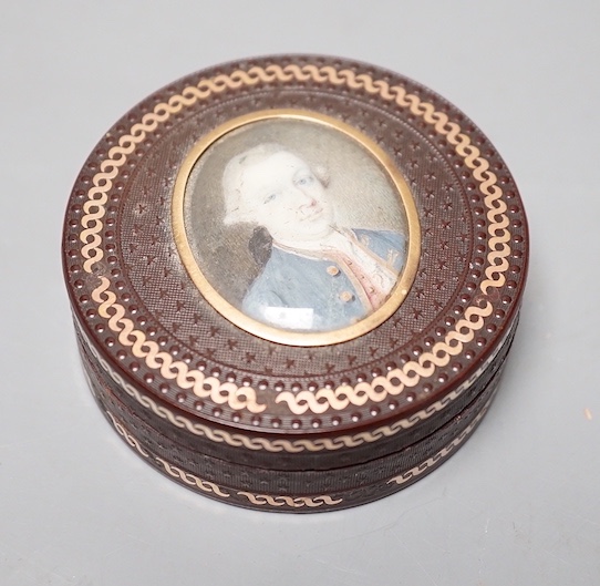 A 19th century pressed bois durci and gilt metal snuff box with painted miniature portrait of a gentleman on ivory to cover. 6cm diameter